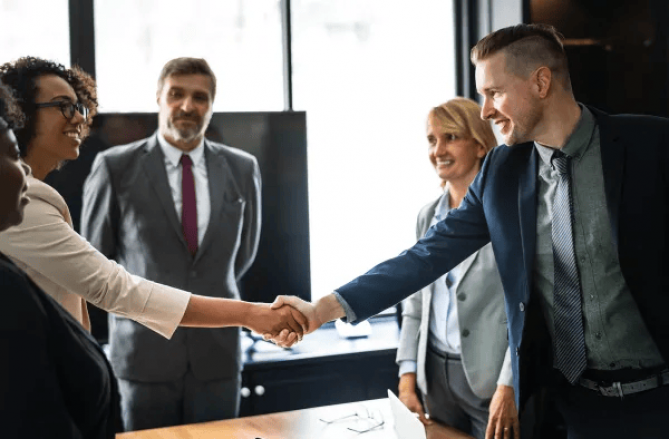 Two people shakes hand in office